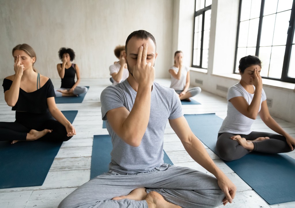 Nhóm người ngồi tập yoga, thực hiện bài tập hít thở sâu giúp điều hòa nhịp thở và hỗ trợ giảm ho do kích thích đường hô hấp.