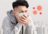 Người đàn ông đeo khẩu trang, ho và che miệng khi có dấu hiệu nhiễm virus đường hô hấp