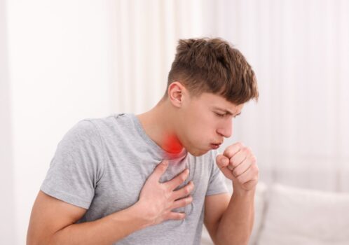 Nam giới ôm ngực và ho, biểu hiện khó chịu vùng ngực và cổ họng