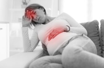 Người phụ nữ bị ho đưa tay ôm vùng bụng, minh họa tình trạng đau bụng khi ho kéo dài hoặc ho dồn dập.