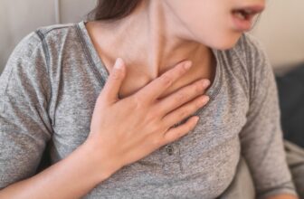 Người bị ho thở khò khè về đêm đặt tay lên cổ họng khi khó chịu
